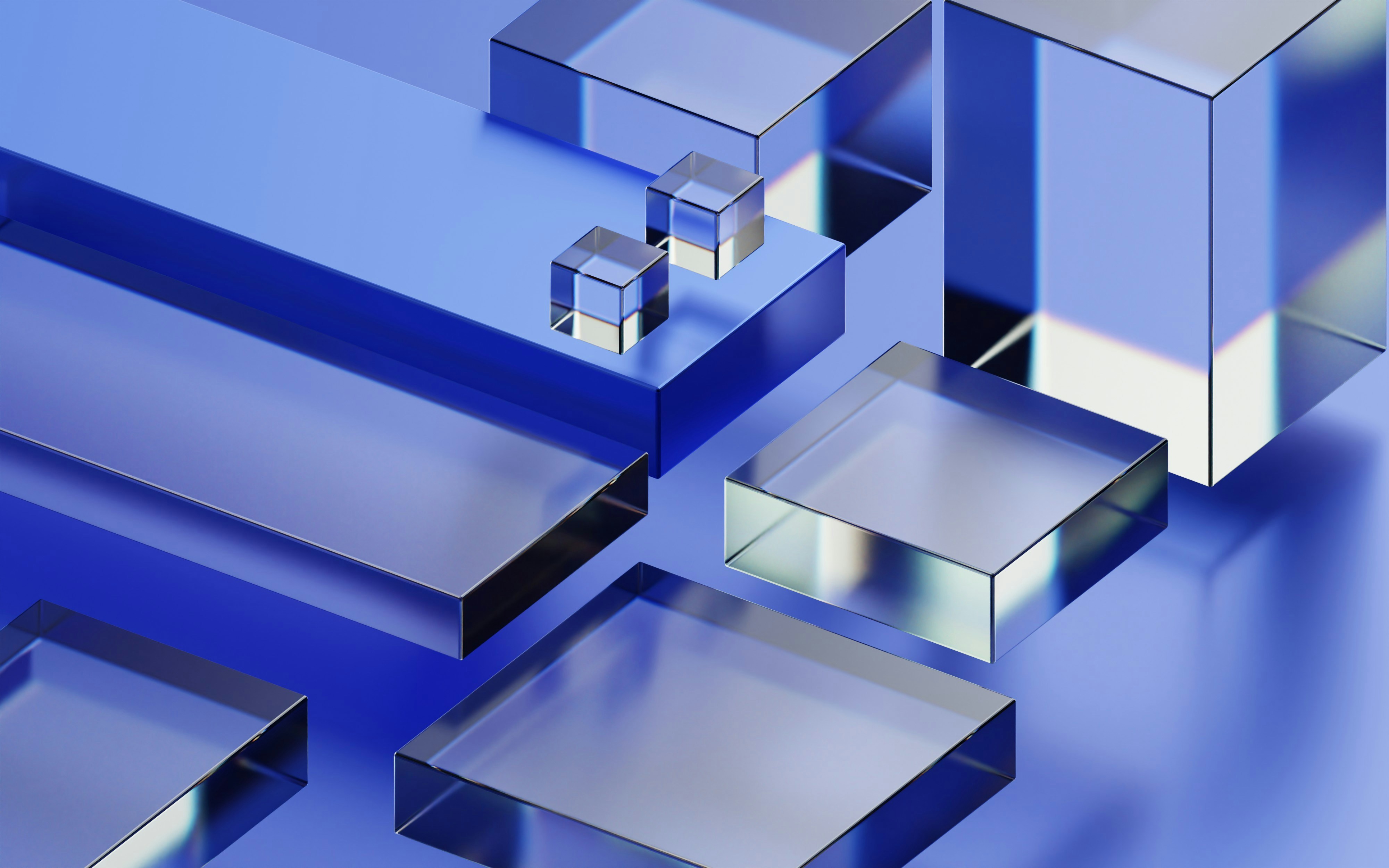 Transparent glass-like geometric shapes including cubes and rectangles on a blue surface.